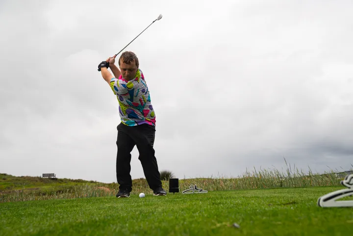 A golfer tees off